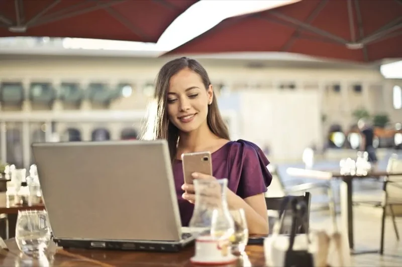 12 informações relevantes para o seu portfolio: mulher vestindo roxo sentada na cadeira enquanto segura telefone.